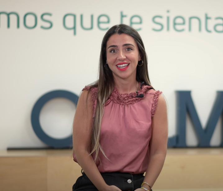 Mujer sonriendo frente a fondo corporativo con el logotipo de Culmia