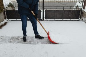 Persona quitando nieve del jardín